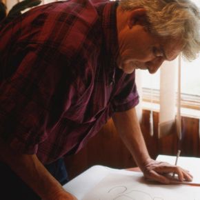 Dessinateur devant sa feuille en train de réaliser un croquis au crayon de papier