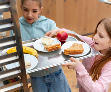 enfant qui range son plateau de cantine